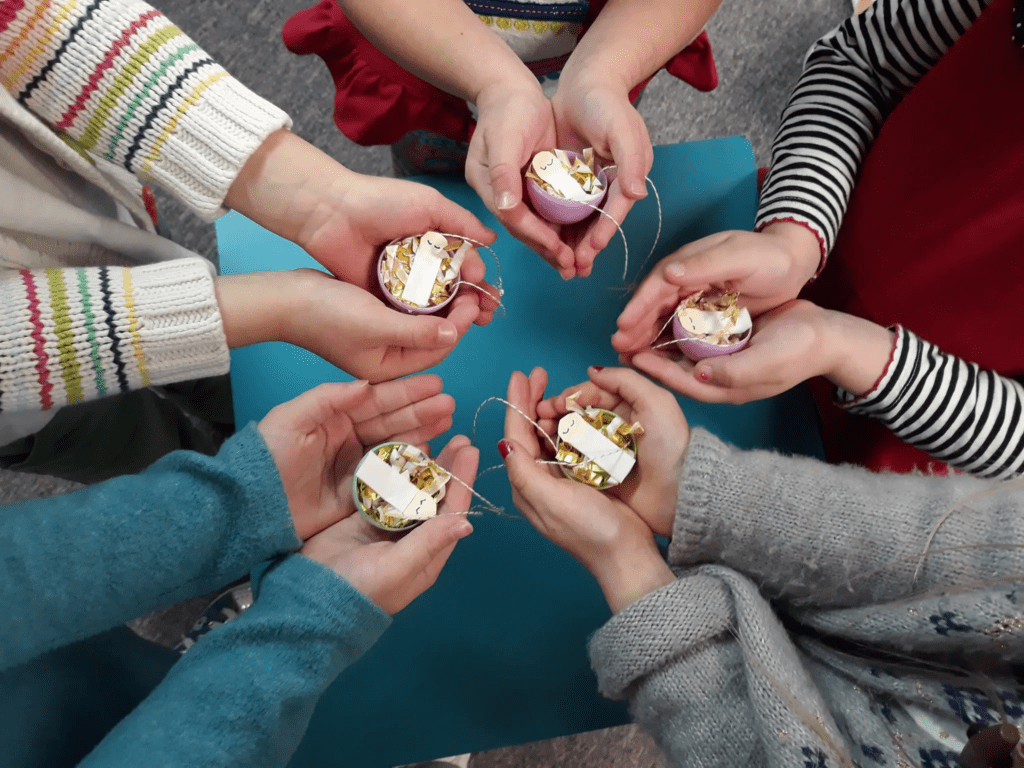 preschoolers holding their baby Jesus projects in their hands in a circle